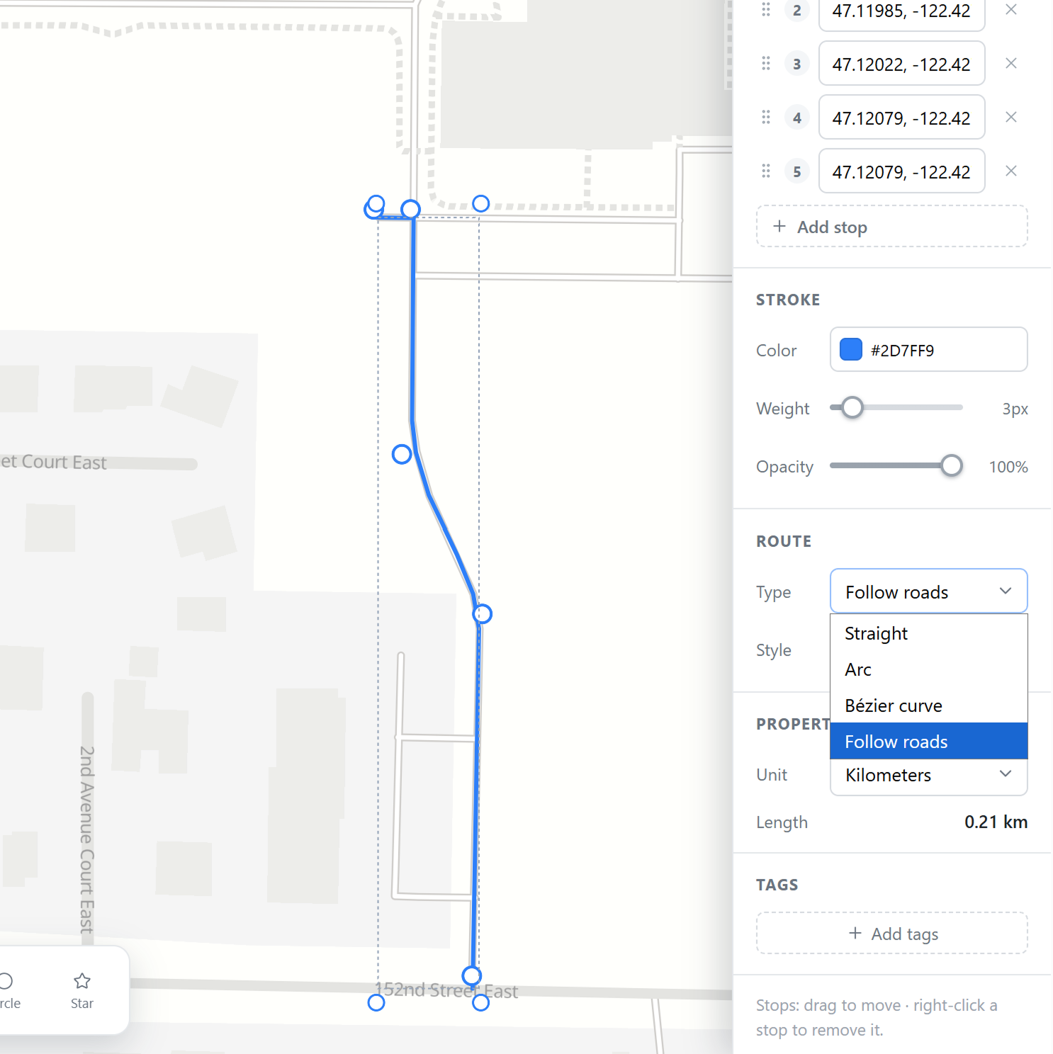 A blue route leading from the parking area and the vendor zone down to the two entrance photo markers